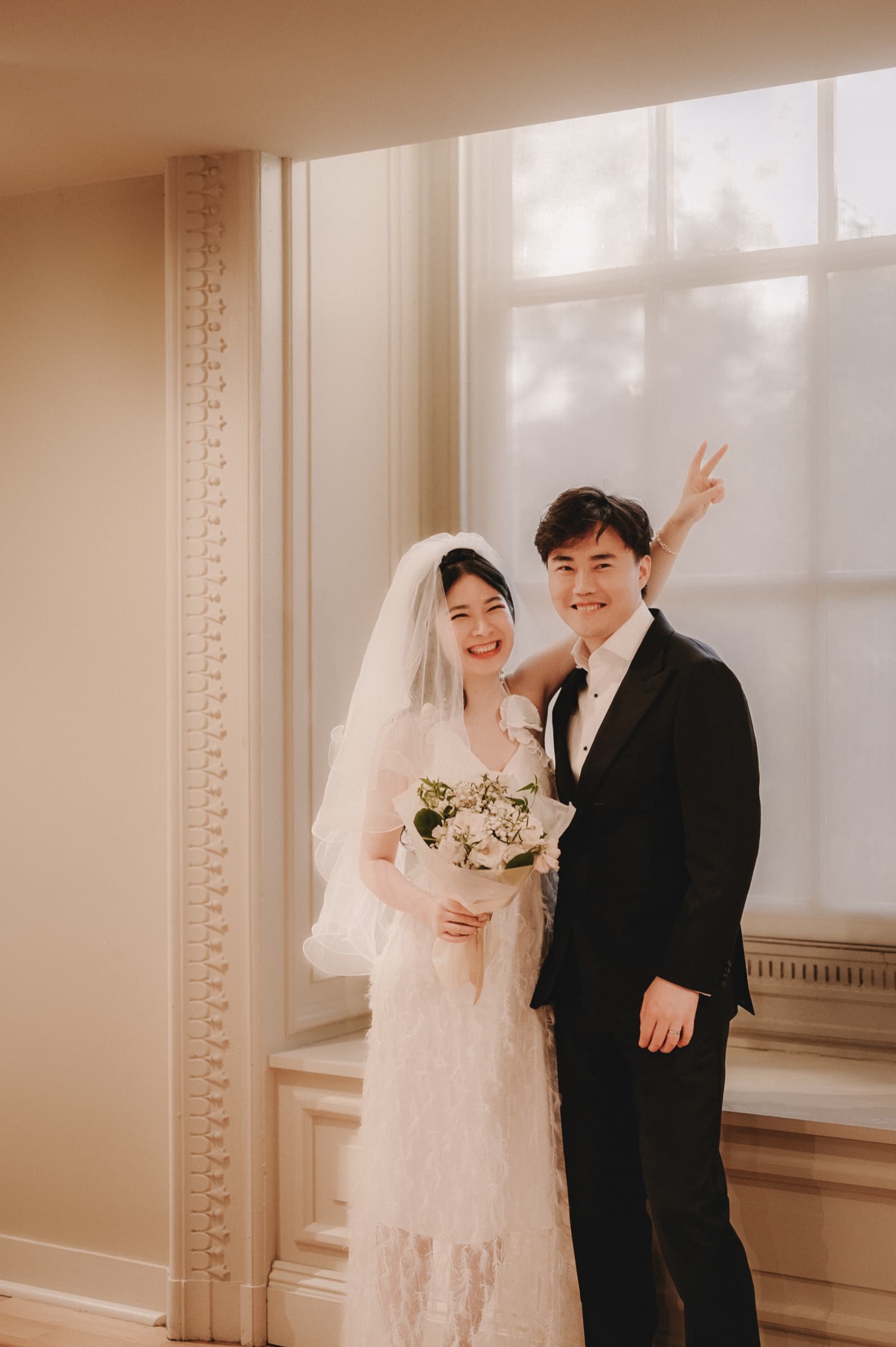 Couple posing together by a sunlit window